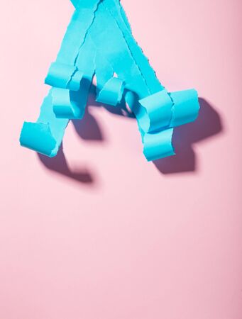 Strips of torn blue paper on a pink backgroundの写真素材