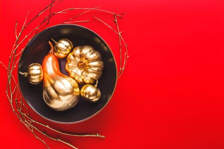 Autumn Frame with Shiny golden Decorative Pumpkins and leaves in bowl. Flat lay, top view trendy holiday concept.の写真素材