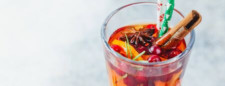 Hot tea with orange slices and cranberries in glass tall glasses. Hot drinks for winter and Christmas.の写真素材