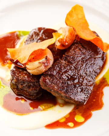 Beef tenderloin medallions with Morne sauce and onion confit in a restaurant serving