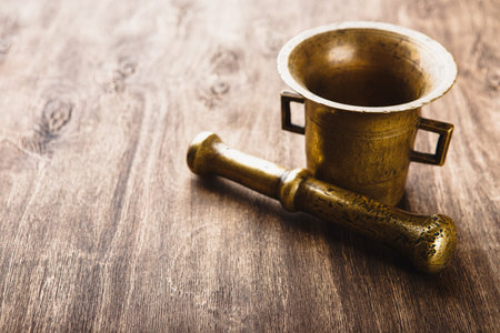 Old Bronze mortar and pestle on wooden background