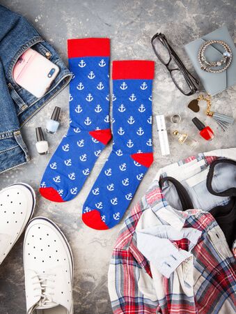 Flat lay fashion photography. Stylish women's outfit. Shoes, jeans, a shirt and a T-shirt, socks and fashion accessories with cosmetics. Fashionable comfortable clothesの写真素材