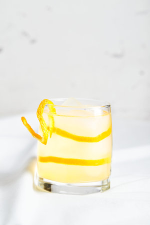 Summer refreshing cocktails, lemonade or mojito with orange zest and ice in a glass on white background. Place for text.の写真素材