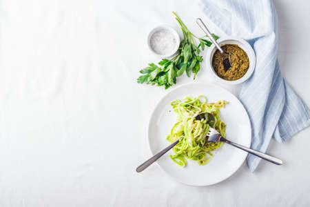 Healthy Zucchini Noddles with pesto on white background. Top view, place for text.の写真素材