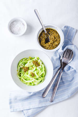 Healthy Zucchini Noddles with pesto on white background. Top view.の写真素材