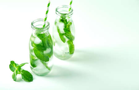 Summer drink, fresh lemonade with mint and ice in glass bottles. Mint infused water, cocktail, detox drink or lemonadeの写真素材