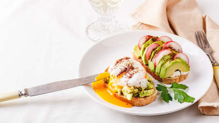 Toast with avocado and poached egg and toast with avocado and radish. Healthy food concept.の写真素材