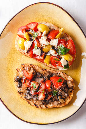 Delicious Bruschetta with tomatoes and mushrooms, and brochette with blue cheese, olives and tomatoesの写真素材