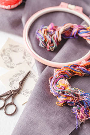 Set for embroidery. Linen fabric, patterns for embroidery, hoop, thread of different colors and needles. Copy space, top viewの写真素材