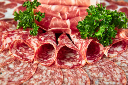 Plate with Assorted different types of smoked sausages, salami and meat, close upの写真素材