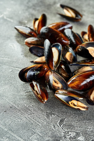 Close-up of big group raw fresh mussels om gray background.