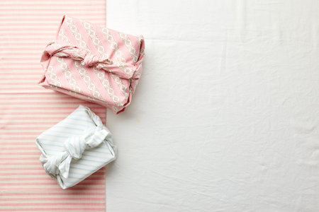Eco-friendly gift wrap in traditional japanese furoshiki style on fabric background, eco-friendly...
