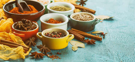 Spices and condiments in small bowls on a blue backgroundの写真素材