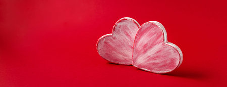 Two valentine hearts made of paper mache on red background. Symbol of love and holiday Valentines...