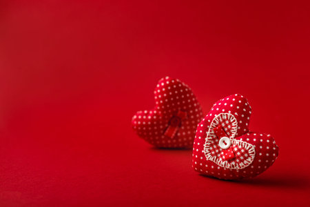 Handmade decorative fabric hearts for Valentines day on red backroundの写真素材