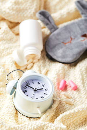 Sleeping mask, alarm clock, earplugs and pills. Healthy night sleep creative concept. Good night, sleep hygiene, insomniaの写真素材