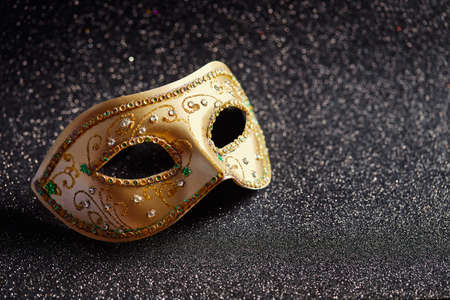 Festive, colorful Mardi Gras or carnivale mask on glitter black background. Venetian masks. Party invitation, greeting card, venetian carnivale celebration concept.の写真素材
