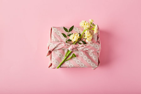 Bouquet of yellow matthiola with gift wrap in traditional japanese furoshiki style. Design concept...