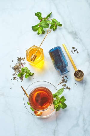 Black tea in glass transparent mug with mint leaves and honey. Calming and revitalizing tea, anti-stress and relaxationの写真素材