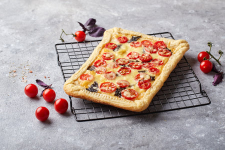 Puff pastry tart with cherry tomatoes, mozzarella and purple basilの写真素材