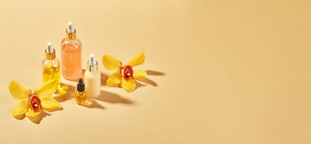 Cosmetic care products in glass bottles with orchid flowers - serums, cream, gel, oils. Concept for...