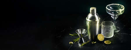 Cocktail shaker and cocktail glasses, and ingredients on dark marble backgroundの写真素材
