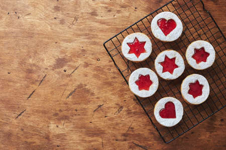 Classic Linzer Christmas Cookies with raspberry or strawberry jam on wooden tableの写真素材