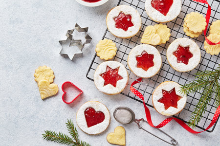 Classic Linzer Christmas Cookies with raspberry or strawberry jam on light background.