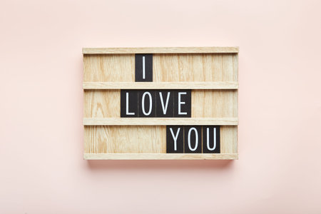 Letter board on pink background. Top view. Romantic background for Valentines day