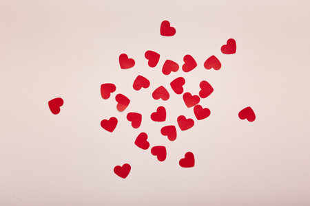 Red paper hearts on pink background. Romantic background for Valentines day