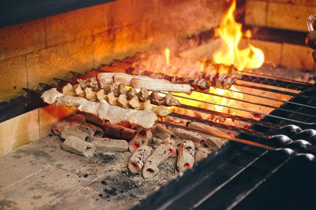Shish kebab on skewers from different types of meat is fried on the grillの写真素材