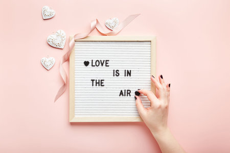 Letter board on pink background. Top view. Romantic background for Valentines day