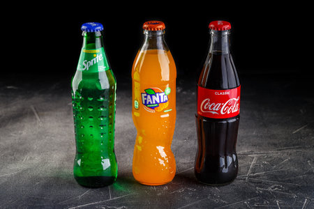 Glass bottles of Coca Cola and Fanta and Sprite soft drink.のeditorial素材