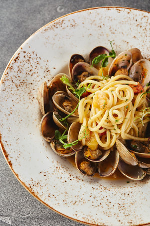 Spaghetti Pasta alle Vongole Seafood pasta with clams in plate on gray background