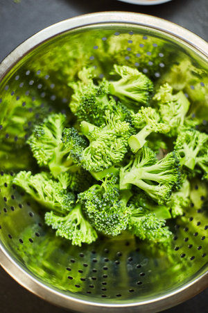 Boiled broccoli in metal colander, close-upの写真素材