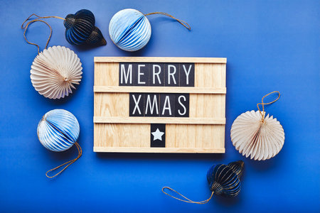 Letter board with text Merry Xmas with christmas decor on blue background. Flatlay.の写真素材