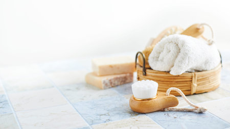 Two bars of soap, wash and massage brushes, and rolled towel. Hygienic bathroom and spa accessories.