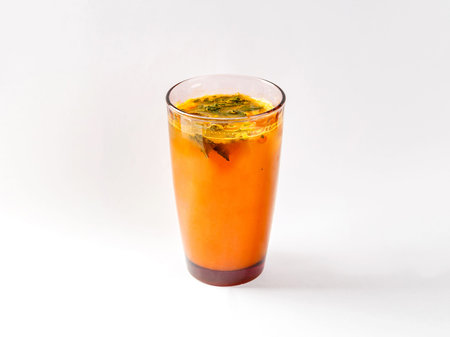 Refreshing drink from sea buckthorn with mint in glass of colored glass on white background.