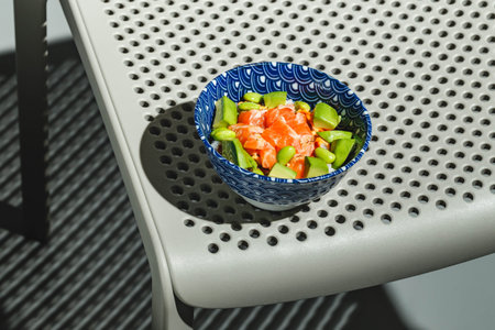 Poke bowl with rice, avocado, edamame beans and smoked salmon. Hard light, deep shadow.