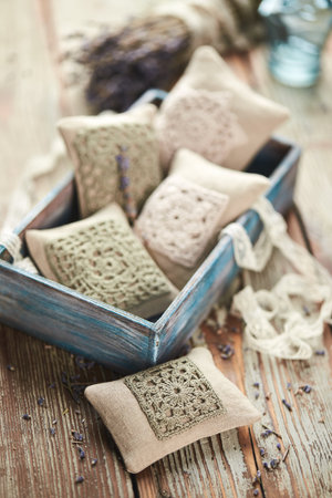 Sachet bags decorated with crocheted lace and lavender on a wooden backgroundの写真素材