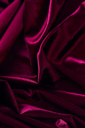 Purple creasy velvet fabric background texture. Empty dark red fabric background of soft and smooth textile material.の写真素材