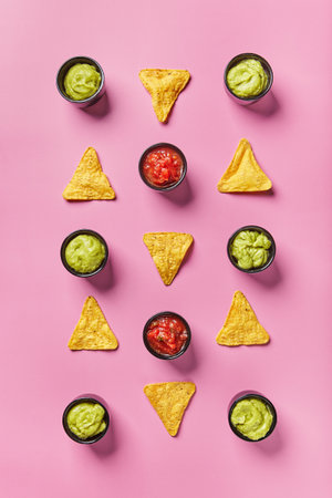 Nachos corn chips with sauce, salsa and guacamole on color background. Mexican cuisine conceptの写真素材