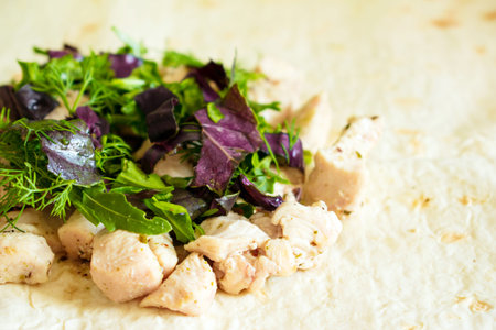 Healthy snack, fitness lunch. Cooking wrapped sandwich gyros â tortillas. Flatbread or pita bread with chicken, basil and dill. Tasty fresh wrap sandwich with chicken, vegetables and greeneryの写真素材