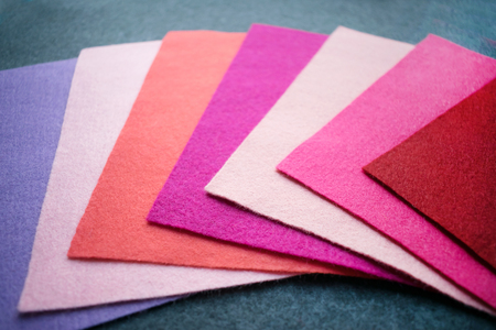 Fan of colored bright felt textile material. Samples of soft felt flaps in different colours. Felt craft abstract handicraft background for handmade and creativeの写真素材