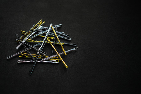 Sparkling metal silver gold and black hairpins on a black background. A pile of hairpins for evening and festive hairstyles. Evening  Hair Accessory, Bridesmaid Hair Pins, Vintage styleの写真素材