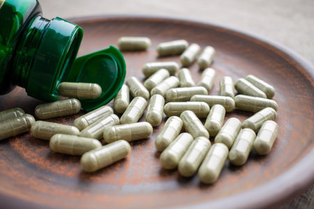 Close up green tea extract capsules and bottle on a clay brown plate on a burlap background. Dietary...