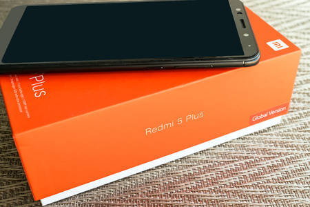 KIEV, UKRAINE - MAY 28, 2018: Xiaomi Redmi 5 Plus black new smartphone with orange box close up developed by Xiaomi Inc. Xiaomi is privately owned Chinese electronic company.のeditorial素材