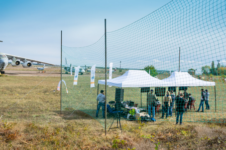 KROPIVNITSKIY, UKRAINE â 07 OCTOBER, 2017: Drone racing among airplanes on the territory of the airfield. Drone racing track with gates and flags on aircraft background. Copters flying and lying at quadcopter competitionのeditorial素材