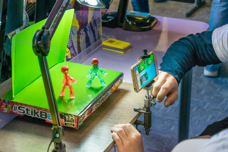 KROPIVNITSKIY, UKRAINE â€“ 12 MAY, 2018: Stop motion animation process with Stikbot details and toy figures. Boy expose stop motion elements to create animations using smartphone