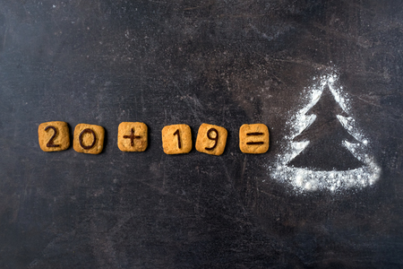 Flour Silhouette Christmas Tree with cookies digits 2019 on dark background with copy space. delicious bakery sweet confectionery Christmas card. Idea of merry new year xmas 2019 holidayの写真素材